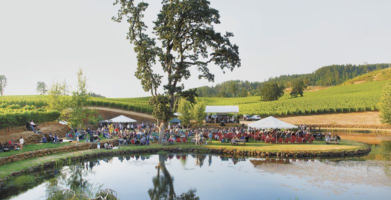Next to the property’s lake, concertgoers enjoy Eola Hills Cellars wine while listening to the music and taking in the views. ##Photo by Rusty Rae