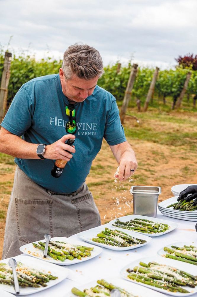Chef Pascal Chureau puts the finishing touches on platters of grilled asparagus for one of his Field and Vine events. ## Photo provided by Field & Vine