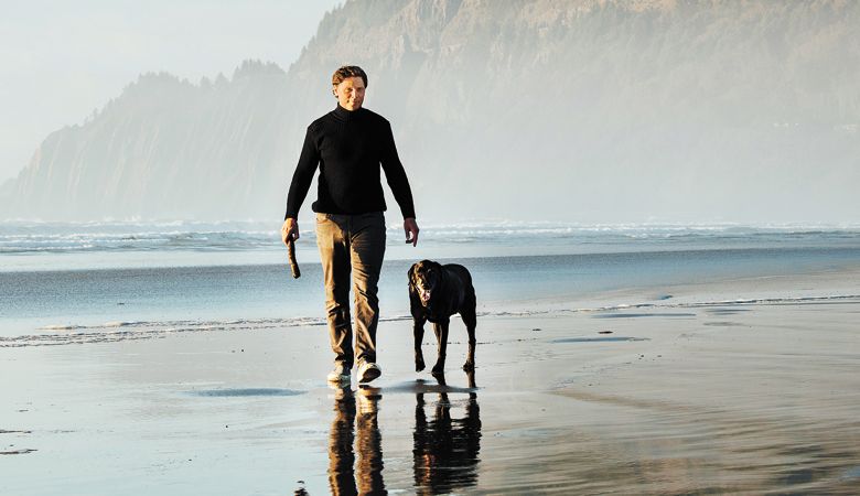 The Winery at
Manzanita owner/
winemaker Mark
Proden takes a
break from business
to walk the
beach with Pinot,
his loyal, furry
companion.##Photo by Kathryn Elsesser