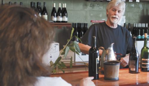 Patrick McElligott talks with a customer at the Oregon Wine Tasting Room near McMinnville, which he managed for 28 years.