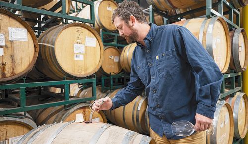 Dustin Andries, head winemaker at Naumes Crush and Fermentation, sampling wine in a barrel. ##Photo by Karen Adair