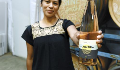 Elena Rodriguez holds a bottle of her recently released Alumbra Cellars 2018 Pinot Noir rosé. ##Photo by Rusty Rae