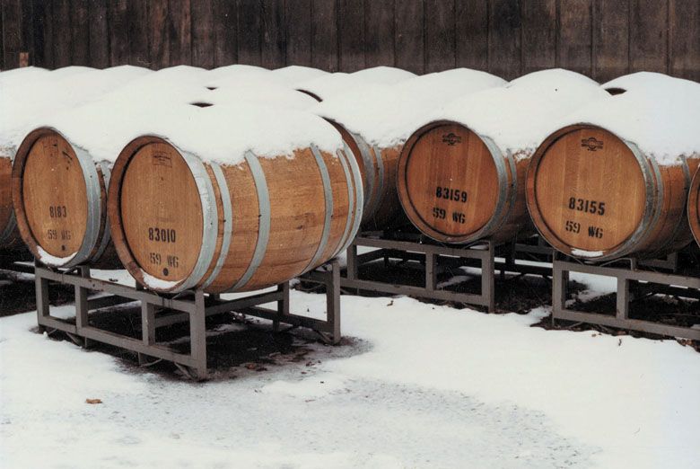 Wine barrels left outside become covered in snow in the winter of 1983— one of the interesting characteristics of winemaking in Oregon compared to other regions around the world.##Courtesy of Erath Winery Collection. Jereld R. Nicholson Library. Linfield University