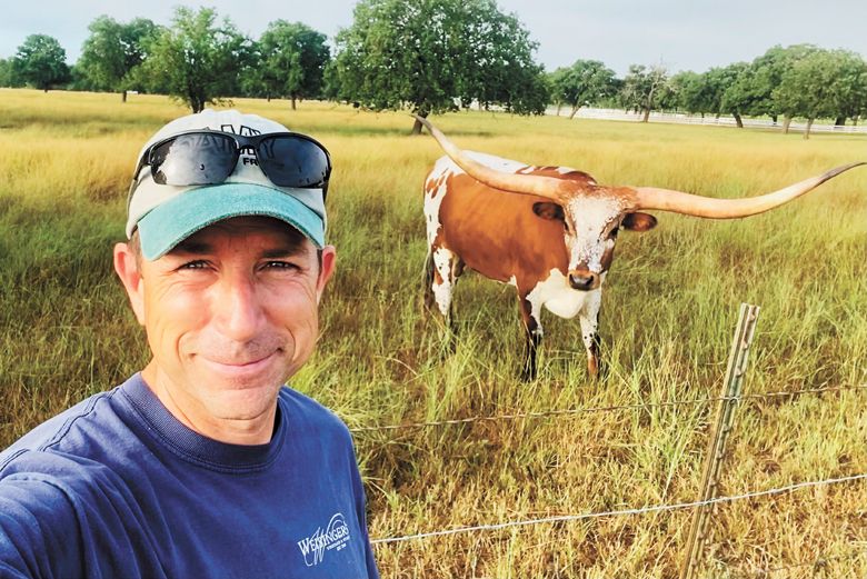 Eric Weisinger poses for a selfie with one of the many Longhorn cattle roaming the Signor property. ##Photo provided by Weisinger Family Winery