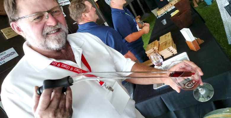 Joe Ginet of Plaisance Ranch pulls a sample with a wine thief during The Founders’ Barrel Auction. ##Photo by Maureen Flanagan Battistella
