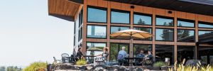Guests enjoying sunshine and views at the new Domaine Willamette Winery. ##Photo provided