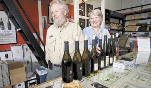 Myron Redford and Viki Wetle, co-owners of Amity Vineyards, beam from behind the tasting bar at the winery. Photo by Marcus Larson,News-Register