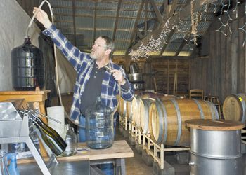 Scott Robbins prepares for bottling at his home outside of Corvallis. Photo by Janis Miglavs.