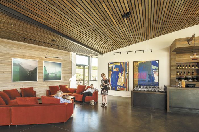 A grouping of velvet couches offer a comfy place to relax with a glass of wine at Saffron Fields. Owners Sanjeev Lahoti and Angela Summers (standing) have displayed their impressive art collection for visitors to enjoy and experience.