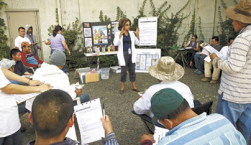 Tuality Healthcare ¡Salud! Services Clinical Nurse Manager Leda Garside talks with vineyard workers during a mobile clinic at Ponzi Vineyards’ winery.