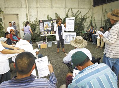 Tuality Healthcare ¡Salud! Services Clinical Nurse Manager Leda Garside talks with vineyard workers during a mobile clinic at Ponzi Vineyards’ winery.