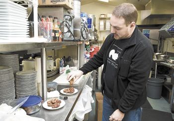 Stefan Czarnecki adds Pinot & Chipotle Sauce to chicken wings in The Joel Palmer
House kitchen in Dayton. Photos by Marcus Larson Stefan Czarnecki adds Pinot & Chipotle Sauce to chicken wings in The Joel Palmer
House kitchen in Dayton. Photos by Marcus Larson