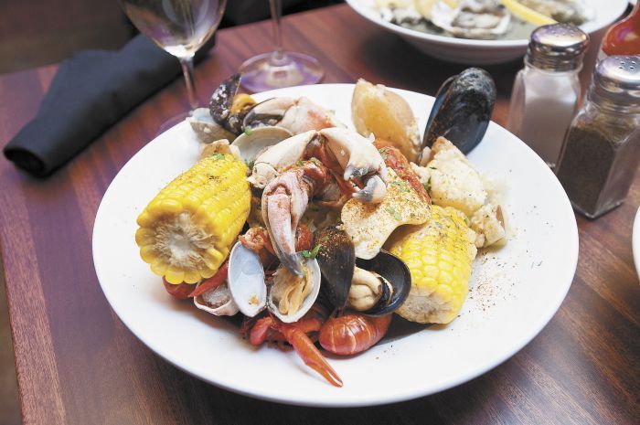 Gem’s Bouillabaisse includes crab claws, crawfish, mussels, Andouille sausage, potatoes and sweet corn in a spicy seafood broth. Photo by Marcus Larson.