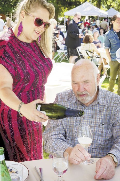 Head sommelier Savanna Ray, dressed up in retro ’80s for IPNC’s 25th anniversary, pours Champagne for Dick Erath at the 2011 event. Photo by Andrea Johnson.