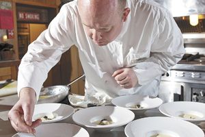 Jason Stoller Smith puts final touches on dishes during the wine dinner.  He began cooking professionally at age 16.  Photo by DS Imagery.