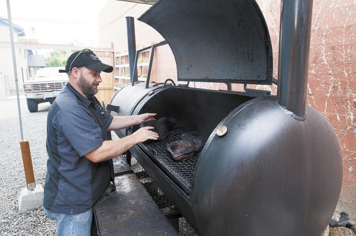 Loal Stahlnecker rotates beef brisket in Storrs’ smoker located behind the restaurant.Photo by Marcus Larson Loal Stahlnecker rotates beef brisket in Storrs’ smoker located behind the restaurant.Photo by Marcus Larson