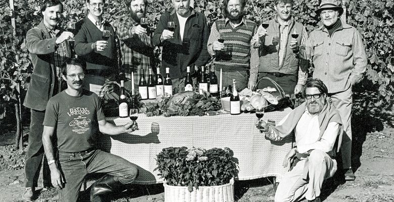 Founding members of the Yamhill County Wineries Association raise their glasses in a toast for a publicity photograph for the first “Thanksgiving Weekend in Wine Country.” Front row (kneeling, left to right): Joe Campbell of Elk Cove Winery, David Adelsheim of Adelsheim Vineyard, back row (standing, left to right): Bill Blosser of Sokol Blosser Winery, Don Byard of Hidden Springs Vineyard, Myron Redford of Amity Vineyards, Dick Erath of Erath Vineyards, Fred Arterberry of Arterberry Winery, Fred Benoit of Chateau Benoit, David Lett of The Eyrie Vineyards.##Photo courtesy of Sokol Blosser Winery and Susan Sokol Blosser.