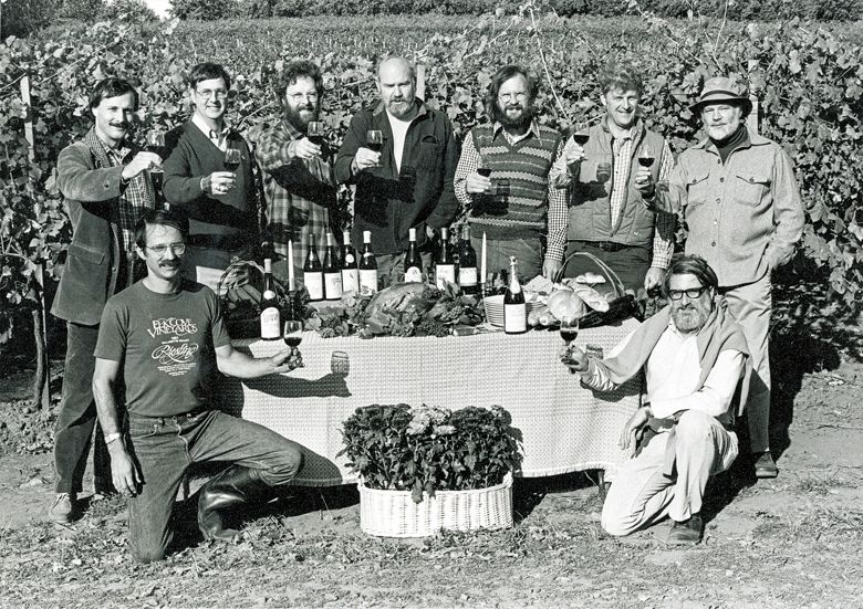 Founding members of the Yamhill County Wineries Association raise their glasses in a toast for a publicity photograph for the first “Thanksgiving Weekend in Wine Country.” Front row (kneeling, left to right): Joe Campbell of Elk Cove Winery, David Adelsheim of Adelsheim Vineyard, back row (standing, left to right): Bill Blosser of Sokol Blosser Winery, Don Byard of Hidden Springs Vineyard, Myron Redford of Amity Vineyards, Dick Erath of Erath Vineyards, Fred Arterberry of Arterberry Winery, Fred Benoit of Chateau Benoit, David Lett of The Eyrie Vineyards.##Photo courtesy of Sokol Blosser Winery and Susan Sokol Blosser.