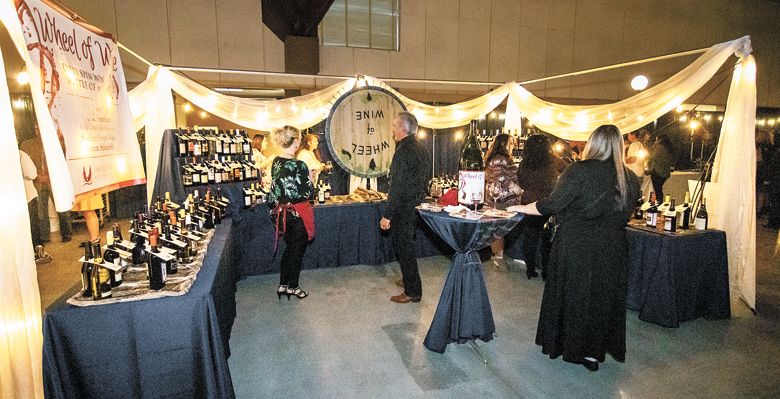 Guests at this year’s Greatest of the Grape spin the Wheel of Wine. ##Photo by McFarland Productions