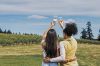 Two women raising their glasses as they look out at a vineyard on a summer day. ## Photo by Gregory Woodman