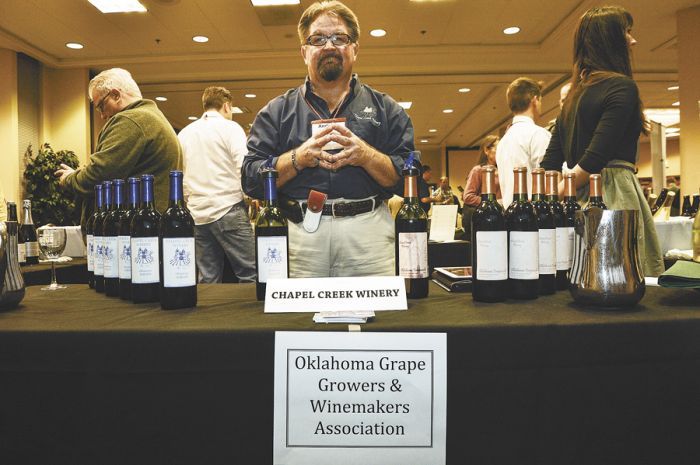 A representative of the Oklahoma Grapegrowers & Winemakers Association offers samples of Chapel Creek wine at the festival. Photo by Andrea Johnson.