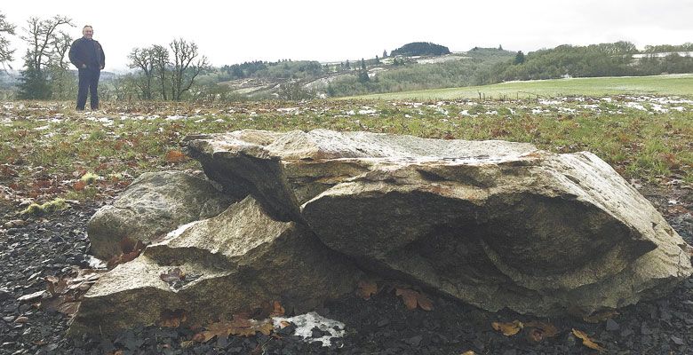 Jack LaRue near the glacial erratic rock that was deposited on his property via the Missoula Floods. ##Photo by Neil Zawicki
