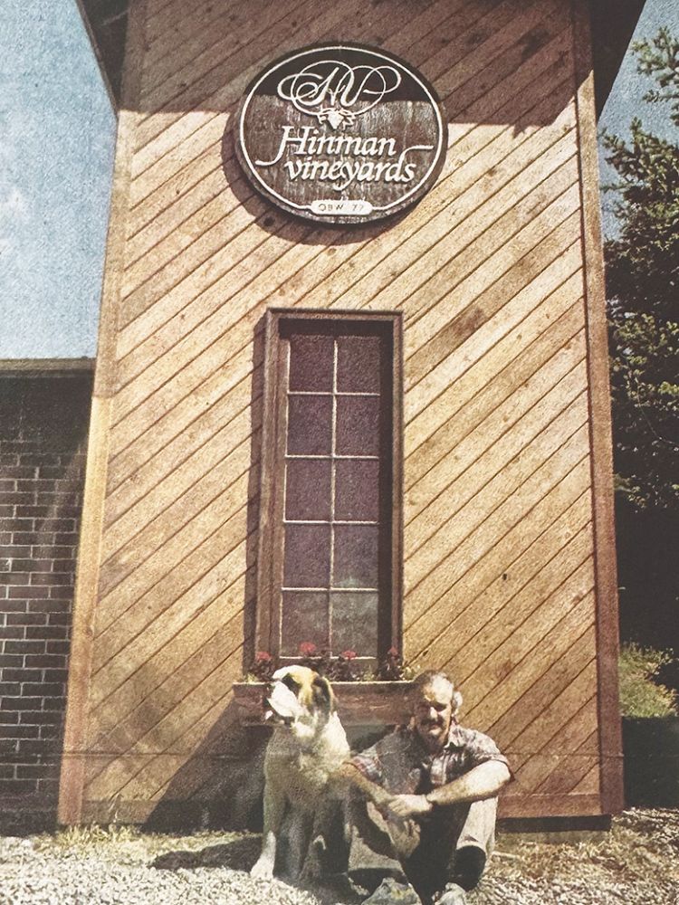 Doyle Hinman sitting with a dog in front of the tower at Hinman Vineyards. ## Photo provided by Hinman Vineyards