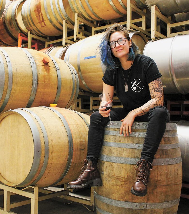 Quady North’s Jorden Williams, sitting atop a barrel in the cellar.##Photo by Sara Garr