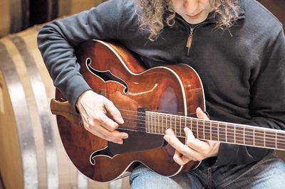 Winemaker Jay Somers strums his Eastman 605 inside his winery, J Christopher.