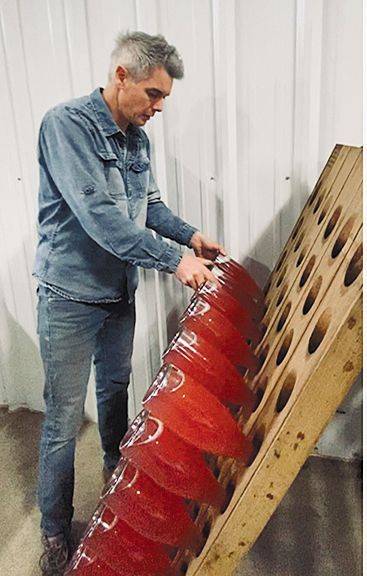 Winemaker Jean-Michel Jussiaume riddling bottles of sparkling wine. ## Photo provided by Maison Jussiaume