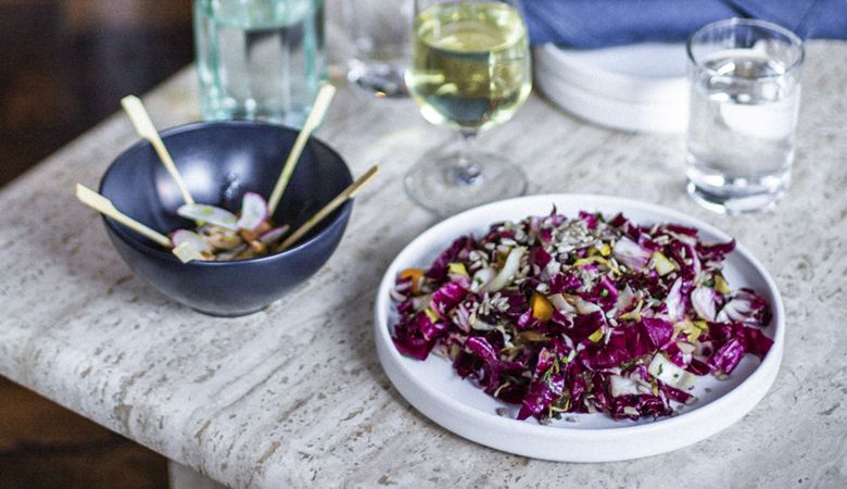 Smoked mussel skewers with pickle, radish and horseradish aioli (left). Chicory salad with caramelized onion, sunfl ower seeds, butternut squash vinaigrette and dill (right). ##Photo by Jeremy Fenske