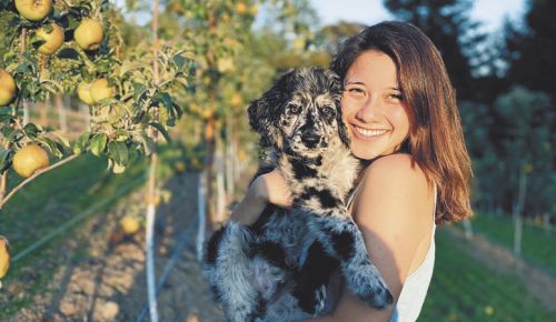Kristof Farms Orchard Cider CEO Caroline Kristof and Tux the puppy are eager to share her family’s new cider with the world. ##Photo by ADAM ELLIS HARPER