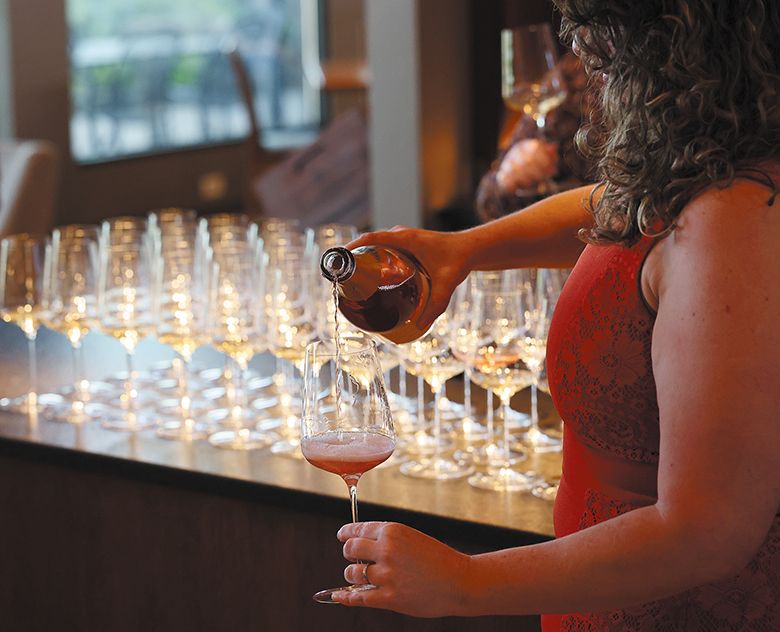 A woman pouring glasses of sparkling wine. ## Photo by Will Hawkins