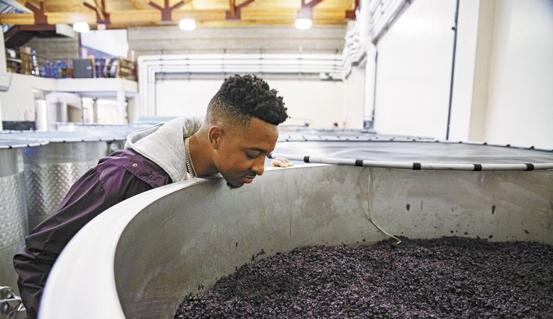 CJ McCollum takes a peek at fermenting Pinot Noir during a tour at Adelsheim Vineyard, where winemaker Gina Hennen makes his wine, ##Photo by Justin Tucker / Nine Eighty Four