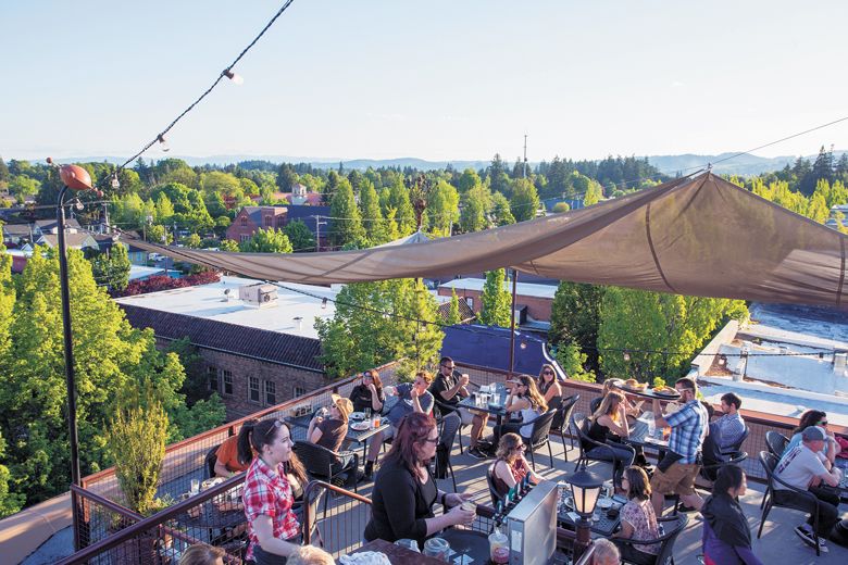 Diners enjoying views high above downtown McMinnville from the rooftop deck at McMenamins Hotel Oregon.##Photo provided by McMenamins