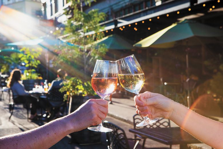 Outdoors on the patio sipping glasses of wine made at Edgefield Winery. ##Photo provided by McMenamins