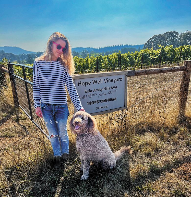 Hope Well Wine&rsquo;s Mimi Casteel petting her dog, Olive, at the entrance to her Sheridan vineyard. ## Photo provided by Hope Well Wine