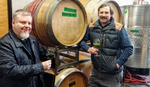 Winemakers Bryum Arnellii and Thomas Monroe salute the latest bottling of moss wine. ##Photo provided