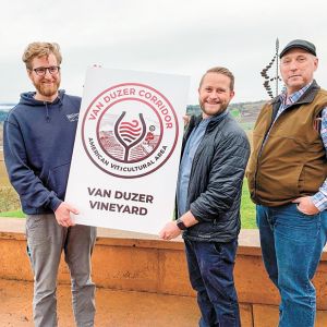 Van Duzer Vineyard staff holding a new sign that AVA member vineyards and wineries will post on their property. From left: Eric Misiewicz, winemaker; Brandon Allen, sales and marketing manager; and Bruce Sonnen, vineyard manager. ##Photo by Patty Mamula