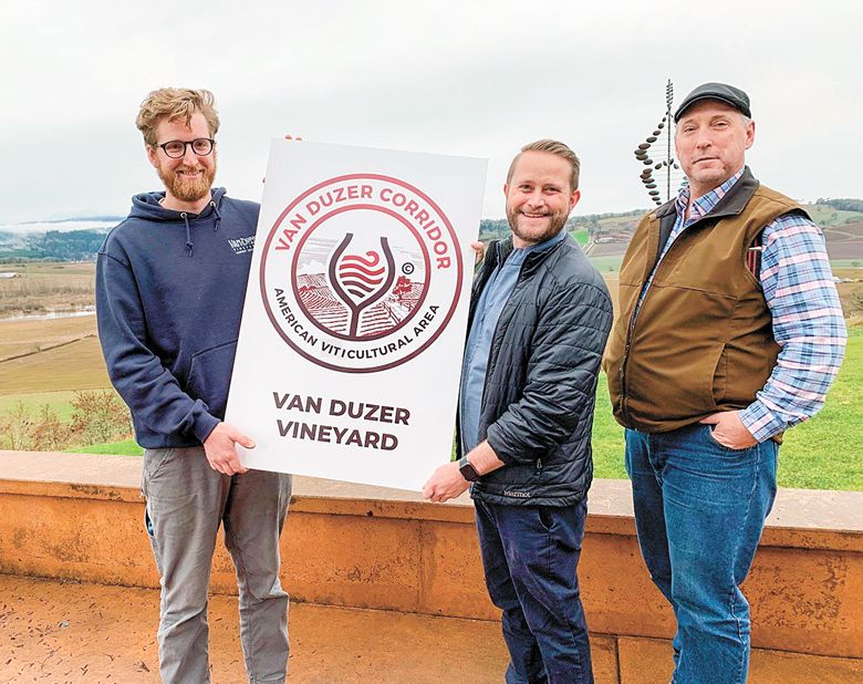 Van Duzer Vineyard staff holding a new sign that AVA member vineyards and wineries will post on their property. From left: Eric Misiewicz, winemaker; Brandon Allen, sales and marketing manager; and Bruce Sonnen, vineyard manager. ##Photo by Patty Mamula