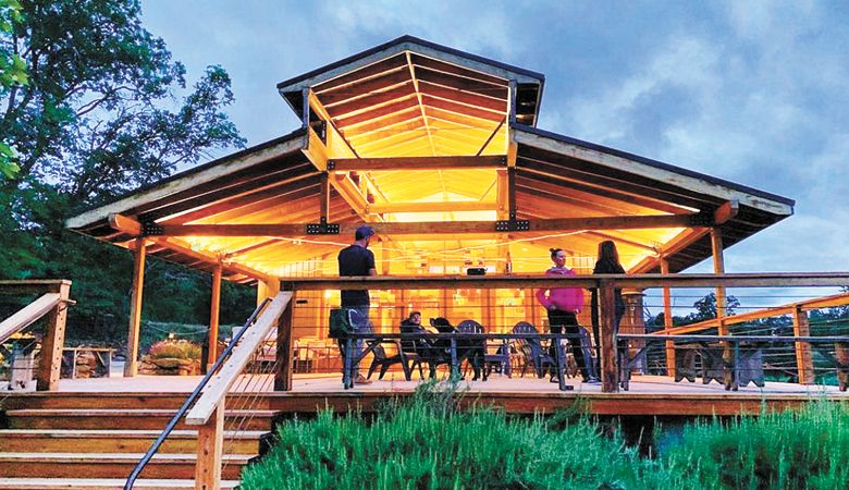 The expanded, redesigned tasting room at Rocky Knoll Vineyard and Dunbar Farms glows as the sun sets in Medford. ##Photo provided