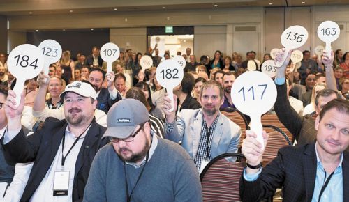 Guests place their bids via paddles at the Willamette: The Pinot Noir Barrel Auction. ##Photo by Aubrie LeGault.