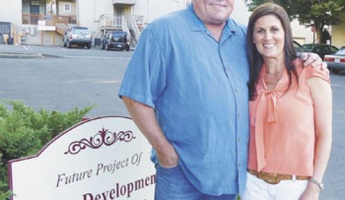 Doug and Dionne Irvine stand in a parking lot that will soon be transformed into a multi-use building called The Vine; it will house a tasting room, boutique inn and more.