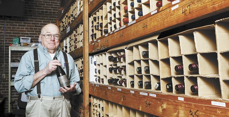 Nick chooses a wine inside the restaurant’s wine cellar, a collection he started 40 years ago. ##Photo by Rockne Roll