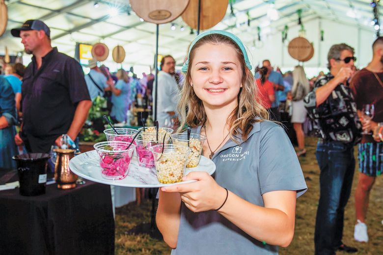 A volunteer feeding guests at the Oregon Wine Experince.##Photo By Steven Addington Photography A volunteer feeding guests at the Oregon Wine Experince.##Photo By Steven Addington Photography