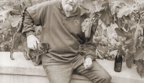 Dick Erath poses for a picture with a cat and a bottle of wine.##Jereld R. Nicholson Library, Linfield university, ¡Salud! Program