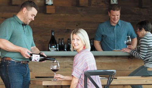 Purple Hands winemaker Cody Wright pour his wife, Marque, a glass of Pinot Noir at the Dundee tasting room on Highway 99W.  ##Photo by Andrea Johnson