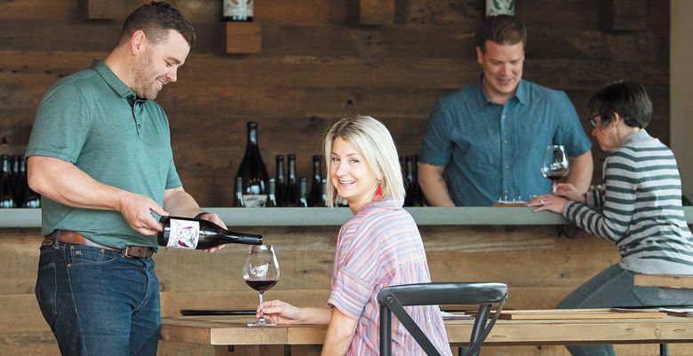 Purple Hands winemaker Cody Wright pour his wife, Marque, a glass of Pinot Noir at the Dundee tasting room on Highway 99W.  ##Photo by Andrea Johnson