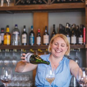 Sommelier Stacey Gibson pouring a glass of sparkling wine. ## Photo by Josh Chang/Foundry 503