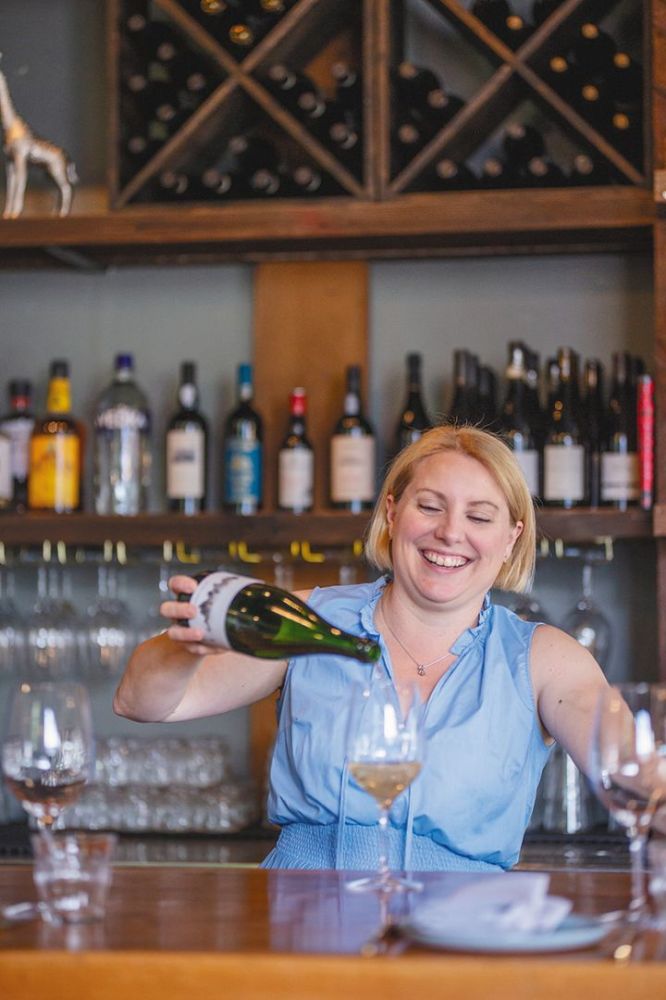 Sommelier Stacey Gibson pouring a glass of sparkling wine. ## Photo by Josh Chang/Foundry 503